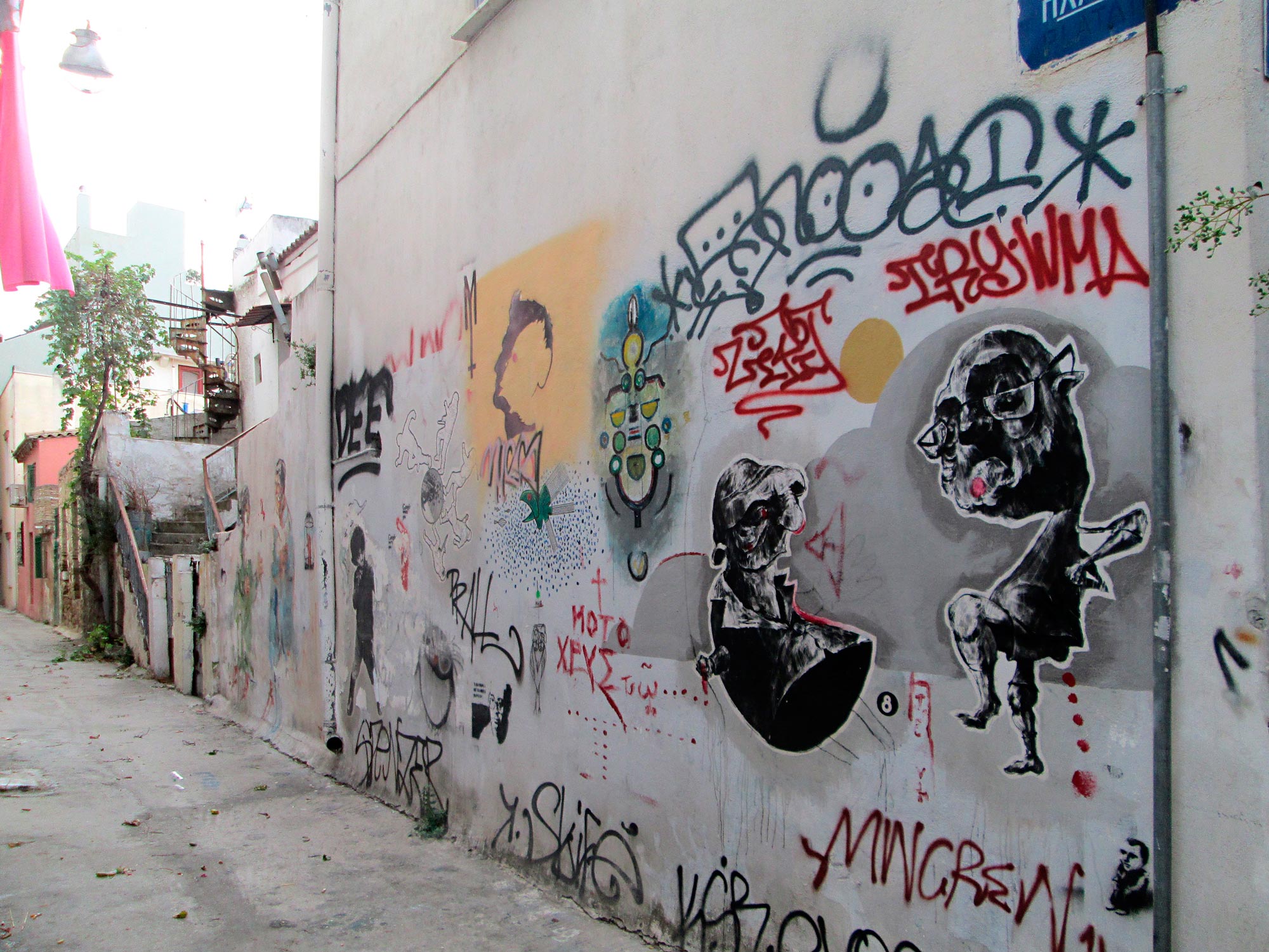 Eine Seitenstra&szlig;e in Athen, die das chaotische nebeneinander von Graffiti und Streetart spiegelt
